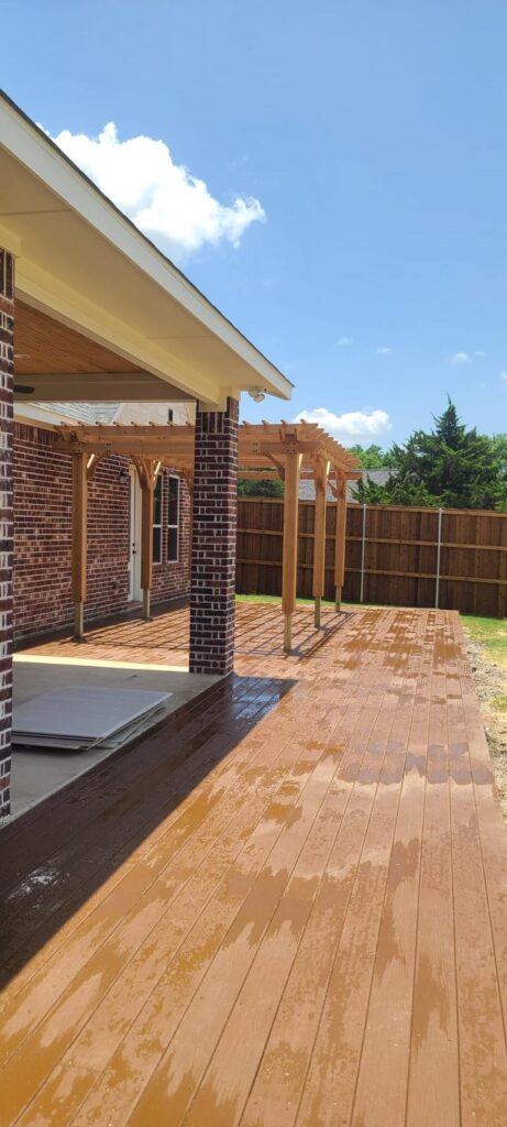Freshly stained wood deck with an attached pergola on a brick home in Alvarado TX