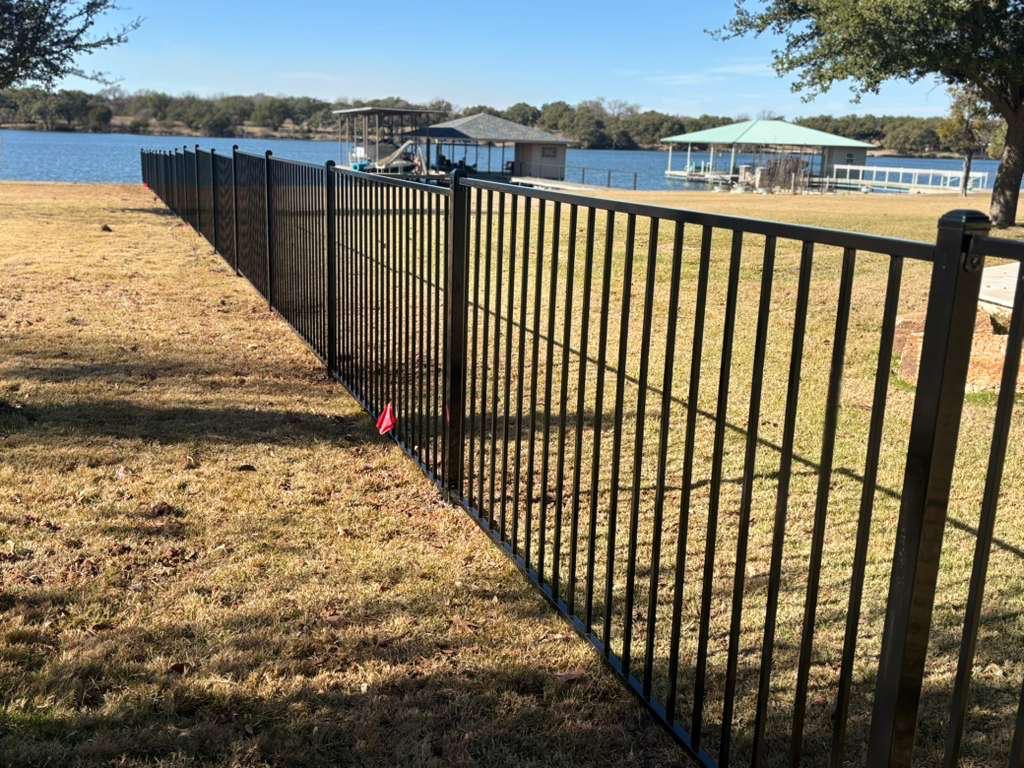 Black aluminum iron-style fence along a lakefront waterfront property in North Texas