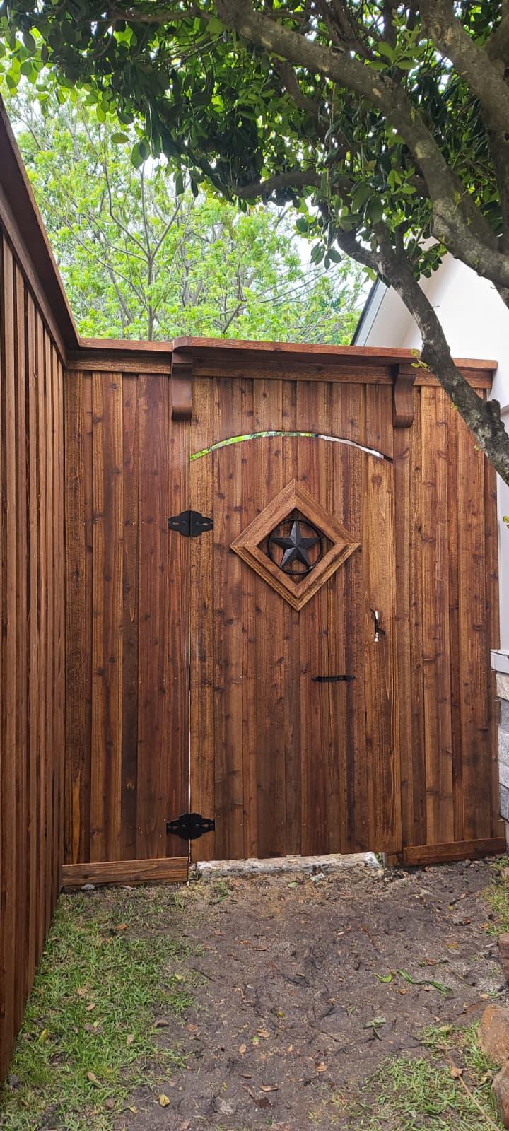 Close-up of an arched cedar gate with Texas star and diamond cutout detail