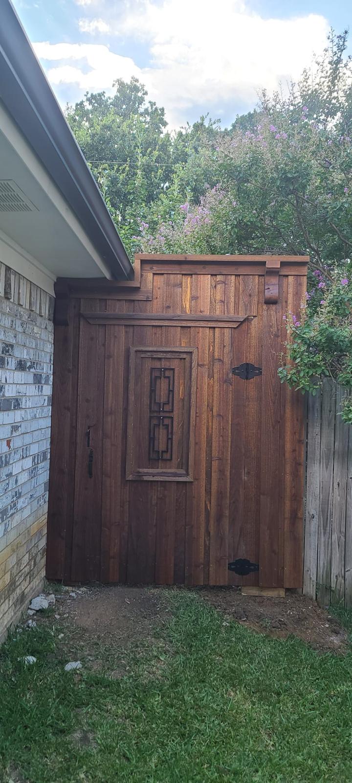 Custom cedar privacy gate with a decorative wrought iron window insert