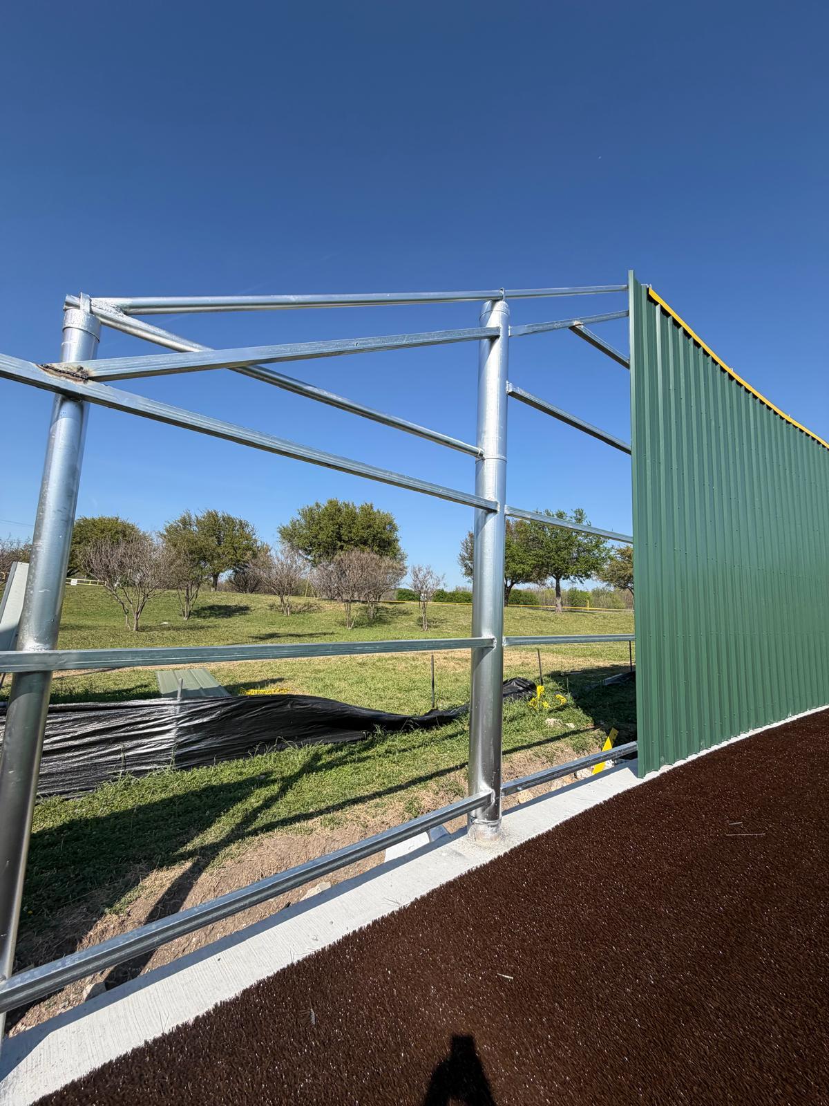 Steel pipe and metal frame ranch fence under construction on Texas acreage