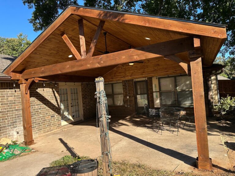 Gable-roof patio cover with exposed cedar beams and a finished wood ceiling